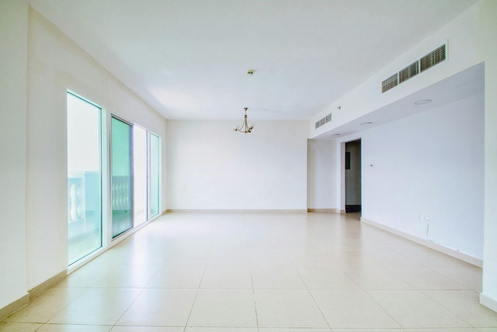 Unfurnished apartment interior with large windows and natural light, ideal for renovation or design projects.